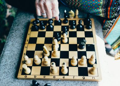 Chessboard with pieces on it and hand over it
