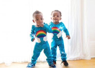 Two little boys in matching rainbow pajamas