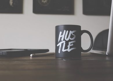 Desk with Hustle coffee cup on it