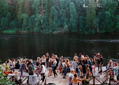 View of crowd of people next to body of water next to trees