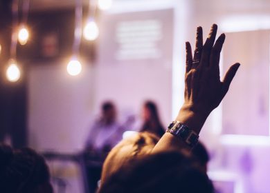 Person with hand up with people in the background