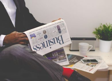 Man sitting with leg crossed holding a Business newspaper