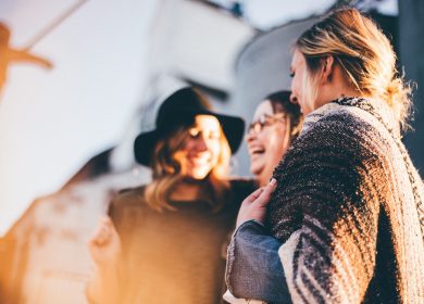 Three women standing together laughing