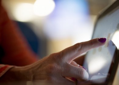 Female hand touching a touch screen device
