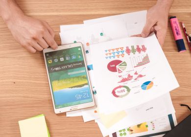 Desk with smartphone and papers with graphs on them